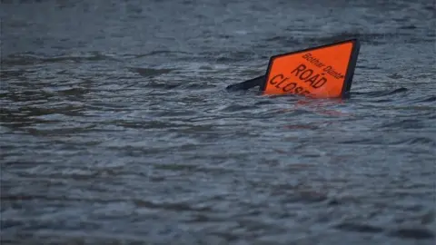 Reuters A "road closed" sign is seen submerged in floodwater during Storm Ophelia in Galway, Ireland 16 October 2017