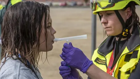 PA Media Woman being given a breath test during a Toxi-triage exercise