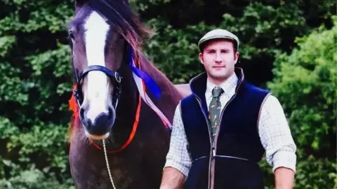 Gloucestershire News Service Scott Manson stood next to a horse