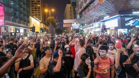 NurPhoto via Getty Images Protesters hold up mobile phone torches during an anti-government protest in Hong Kong, on 27 October, 2019