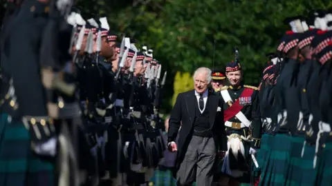 PA Media King Charles inspects an honour guard at the Palace of Holyroodhouse