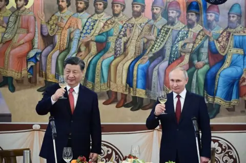 Getty Images Russian President Vladimir Putin and China's President Xi Jinping hold glasses during a reception following their talks at the Kremlin in Moscow on March 21, 2023.