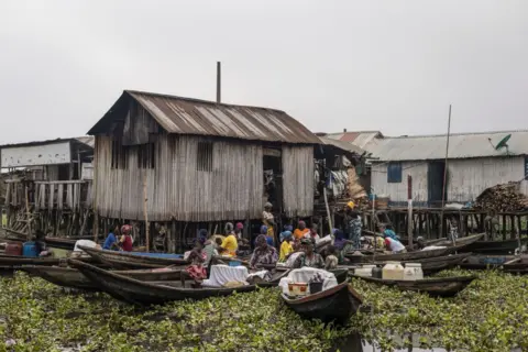 Marco Longari/AFP Perahu berkumpul di luar rumah panggung