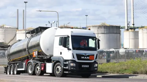 Neil Hall / EPA A white tanker truck enters the Navigator Terminal in Grays in April, with oil, gas and fuel storage units in the background on a cloudy day.
