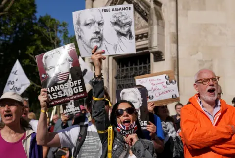 Reuters Supporters of Julian Assange holding placards outside the High COurt in London