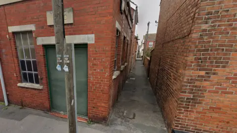A narrow alleyway between terraced brick houses in Stanley Street, Weymouth