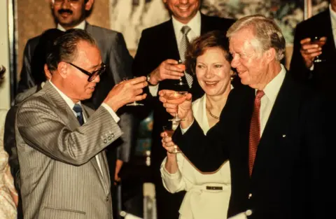 Getty Images Perdana Menteri Tiongkok Zhao Ziyang bersulang dengan pasangan suami istri, mantan Ibu Negara AS Rosalyn Carter dan mantan Presiden AS Jimmy Carter, Beijing, Tiongkok, 29 Juni 1987. 