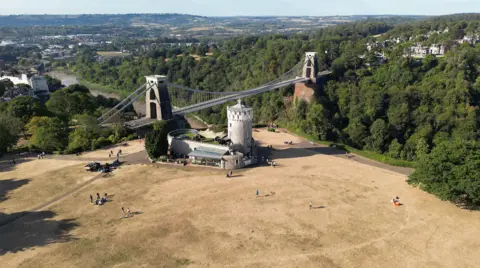 The grass around Clifton Observatory and Clifton Suspension Bridge is parched and dried out after a period of hot weather.
