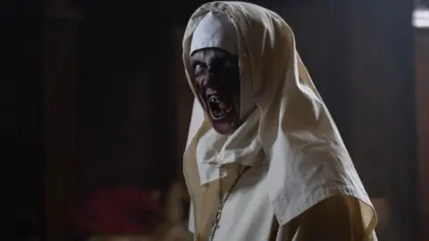 Catherine Frawley An evil-looking monster in a nun outfit baring her teeth