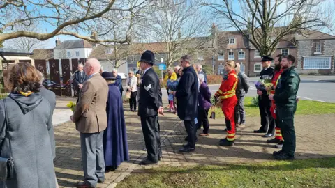 Dorset Council People standing for a minute's silence at Memorial Corner in Dorchester on Sunday.