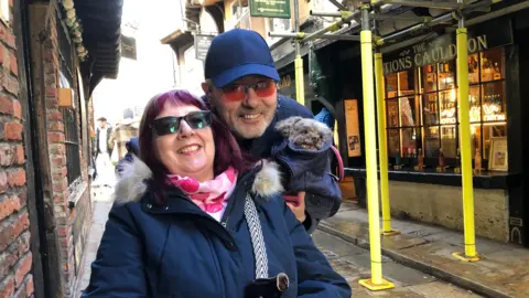 BBC / Naj Modak Woman in wheelchair and man with dog on Shambles with scaffolding