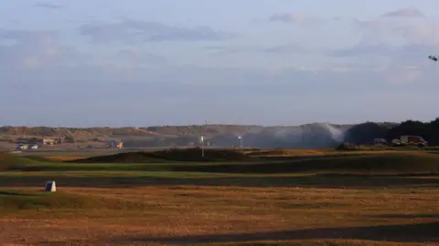 Jack Chiverton A landscape shot of the golf course, smoke can be seen.