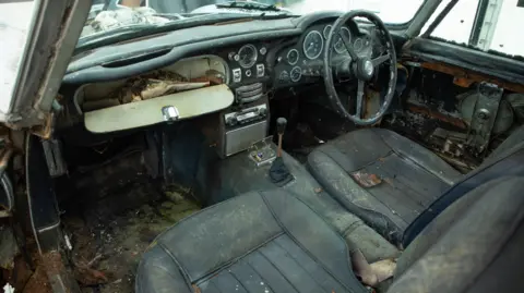 Marc Bow/Timbuktu Content Interior of the car as it was with dirty seats and lots of debris and papers in the glove box
