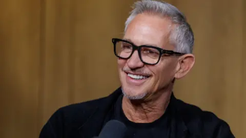 Gary Lineker smiling. He wears a black top.