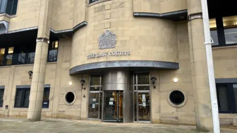 Stock image of the entrance to Bradford Crown Court, with The Law Courts above a revolving door.