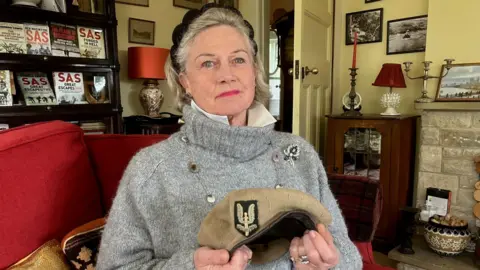 Joanna Burri-Weaver proudly holds her father Peter's beret.