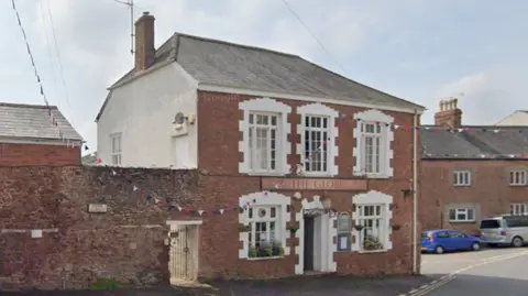 Google external image of The Globe pub. Red brick two floor building with white windows.