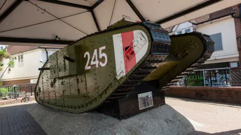 A World War One tank, painted in green with some bits of red and white. It is on display the at the centre of town.