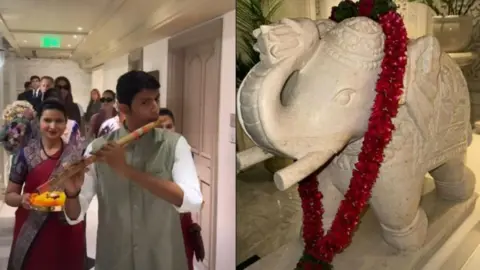 Instagram A man playing flute leading women carrying plates of flower petals, and an elephant decoration