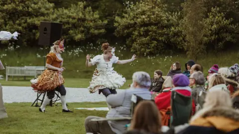 Two people dancing in front of a crowd of people.