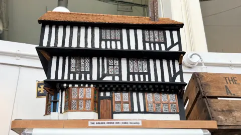 A model of a timber-framed building, Coventry's Golden Cross pub, sits among exhibits