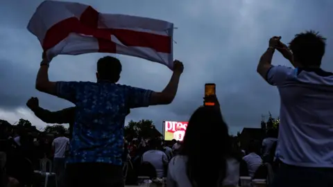 PA Media A group of football fans watching the England football match in Cheltenham, Gloucestershire.
