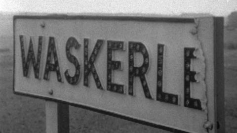 A town sign reading "WASKERLEY", but the last Y has broken off.
