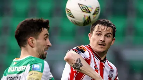 Shamrock Rovers' Neil Farrugia contests the ball with Derry defender Ciaran Coll 