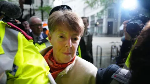 Getty Images Ex-Post Office chief executive Paula Vennells surrounded by police and media, pictured in May when she appeared at the Horizon inquiry