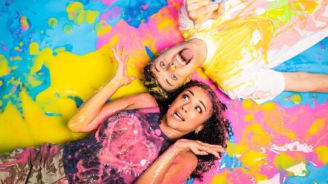 Two people covered in colourful slime