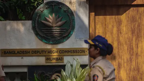 EPA An Indian policewoman walks outside the Bangladeshi Embassy, as supporters of Hindu organizations protest against the arrest of two priests, in Mumbai, India, 02 December 2024.