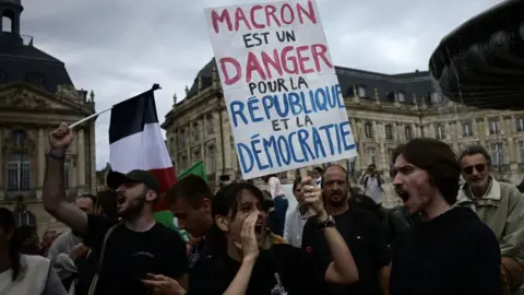 Getty Images Chanting protesters in Bordeaux march with a sign that reads: "Macron est un danger pour la republique et la democratie"