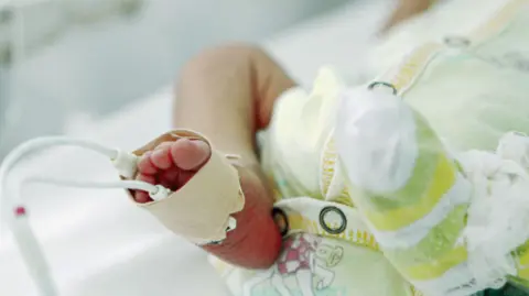 The legs of a small baby in an incubator 