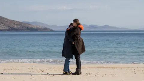 Black Camel Pictures/BBC Alba/John Maher A scene filmed on a beach showing Sorcha Groundsell's character, right, comforting another character in the show. 