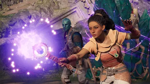 Obsidian Screenshot shows a character wielding a large magical staff which emits a spherical purple glow from its end. A green-skinned companion character looks on as she casts the spell, wisps of purple magic floating around her.