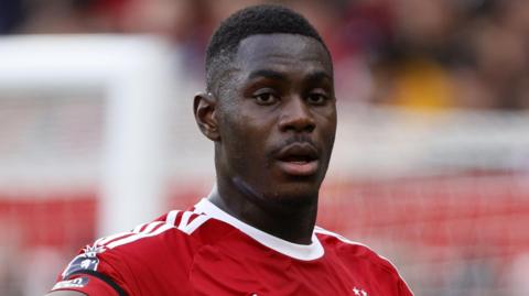 A close up image of Moussa Niakhate wearing Nottingham Forest's red home kit 