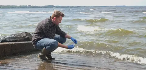 QUB Dr Neil Reid taking samples on the shores of Lough Neagh