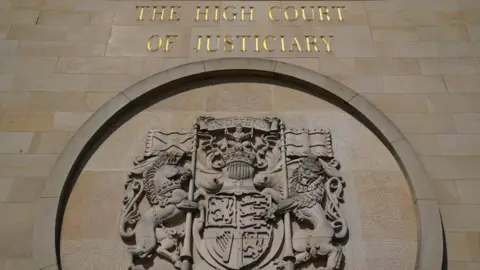 PA Media High Court in Glasgow, emblem on wall, with words The High Court of Justiciary.