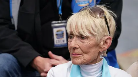 Getty Images Close-up of Gina Campbell. She is looking to her right. She has short blonde hair and a pair of sunglasses propped on her head.