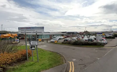 Google A Falkirk council vehicle maintenance centre with a car park to the right of the building filled with cars 