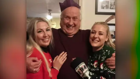 A family pose for a photo on Christmas Day