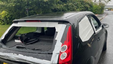 Abandoned car with smashed window in Exminster