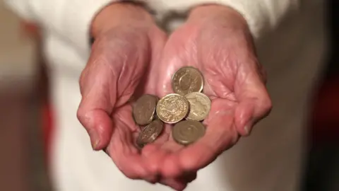 PA Media Pensioner holding coins