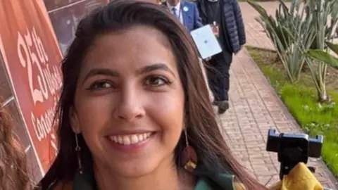 Family Handout/PA Media A headshot of Vitoria Figueiredo Barreto. She is wearing earing and smiling while looking into the camera. 