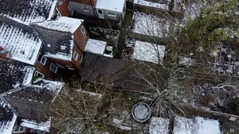 PA Media An aerial view of gardens, showing the garden where Abiyah was found covered in black tarpaulin