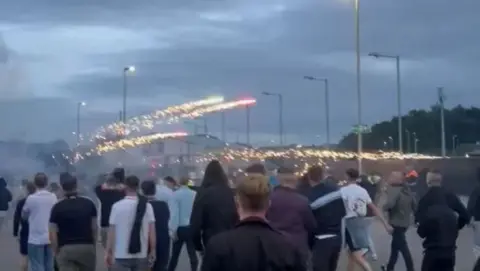 Social Media Shows large groups of people watching flares overhead 