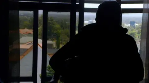 Man silhouetted by a window