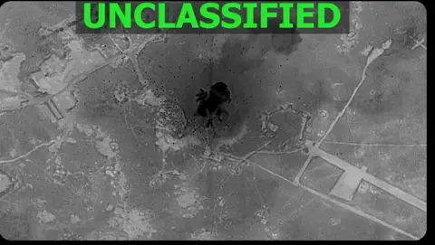 screenshot from a video posted by US Central Command, showing an explosion in an area of land, with the word "unclassified" written across the top
