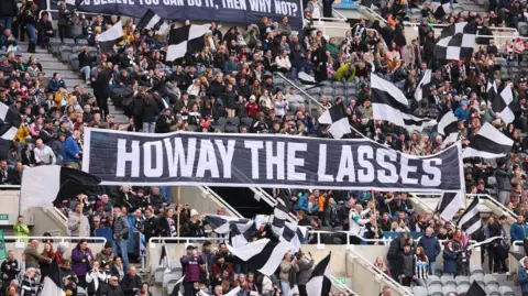 Ed Sykes/The FA/Getty Images A black and white banner in a football stand reading "howay the lasses"