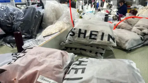 De minimis: How US shoppers will be hit as the tariff exemption ends 3 Reuters Packs of clothing are pictured at a garment factory for Shein in Guangzhou, Guangdong province, China 1 April, 2025.